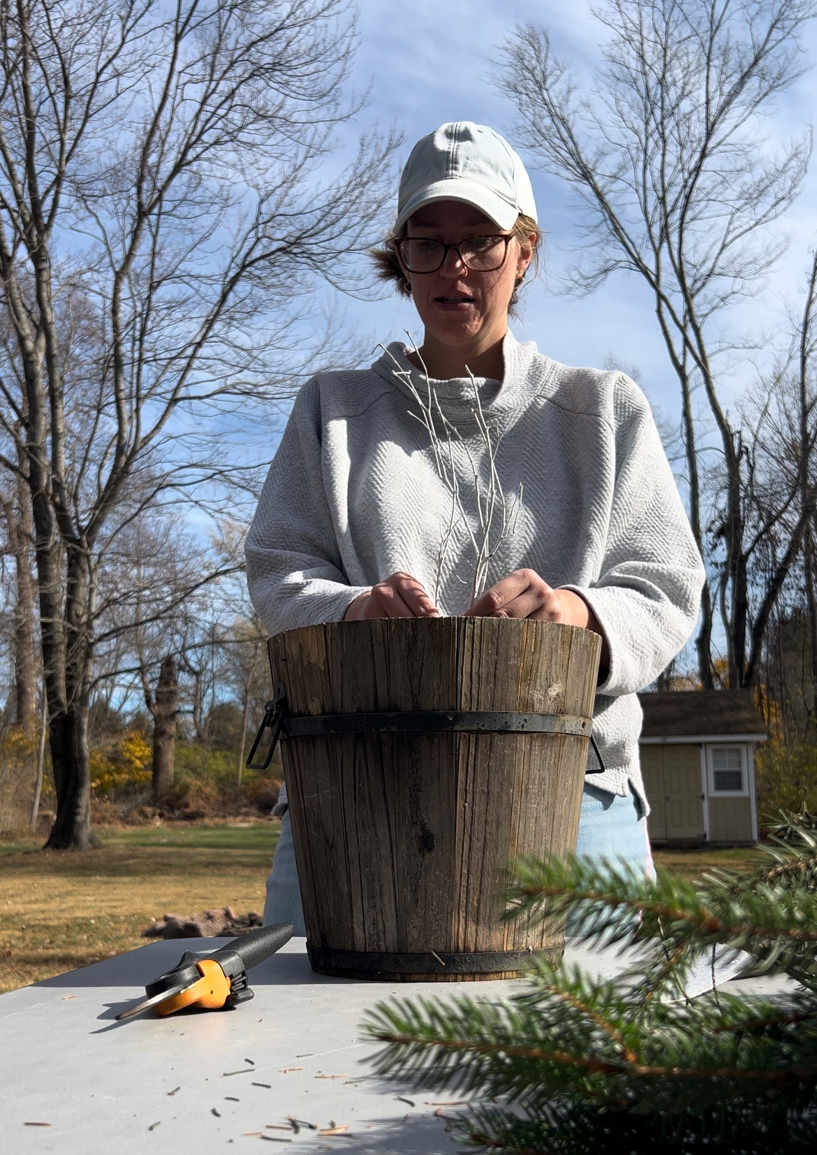 woman making winter porch pot with branch decoration