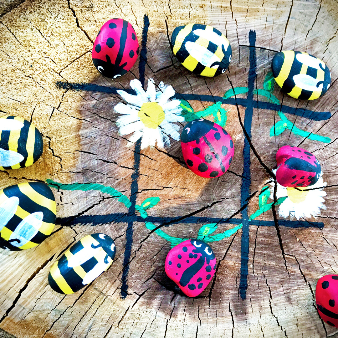 handmade tree stump tic tac toe with painted ladybug and bumble bee hand painted stones